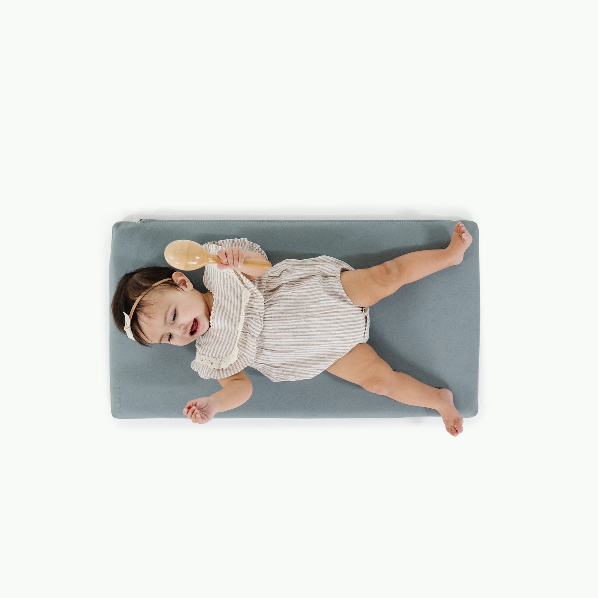 Amalfi (on sale)@overhead of little girl laying on padded mat