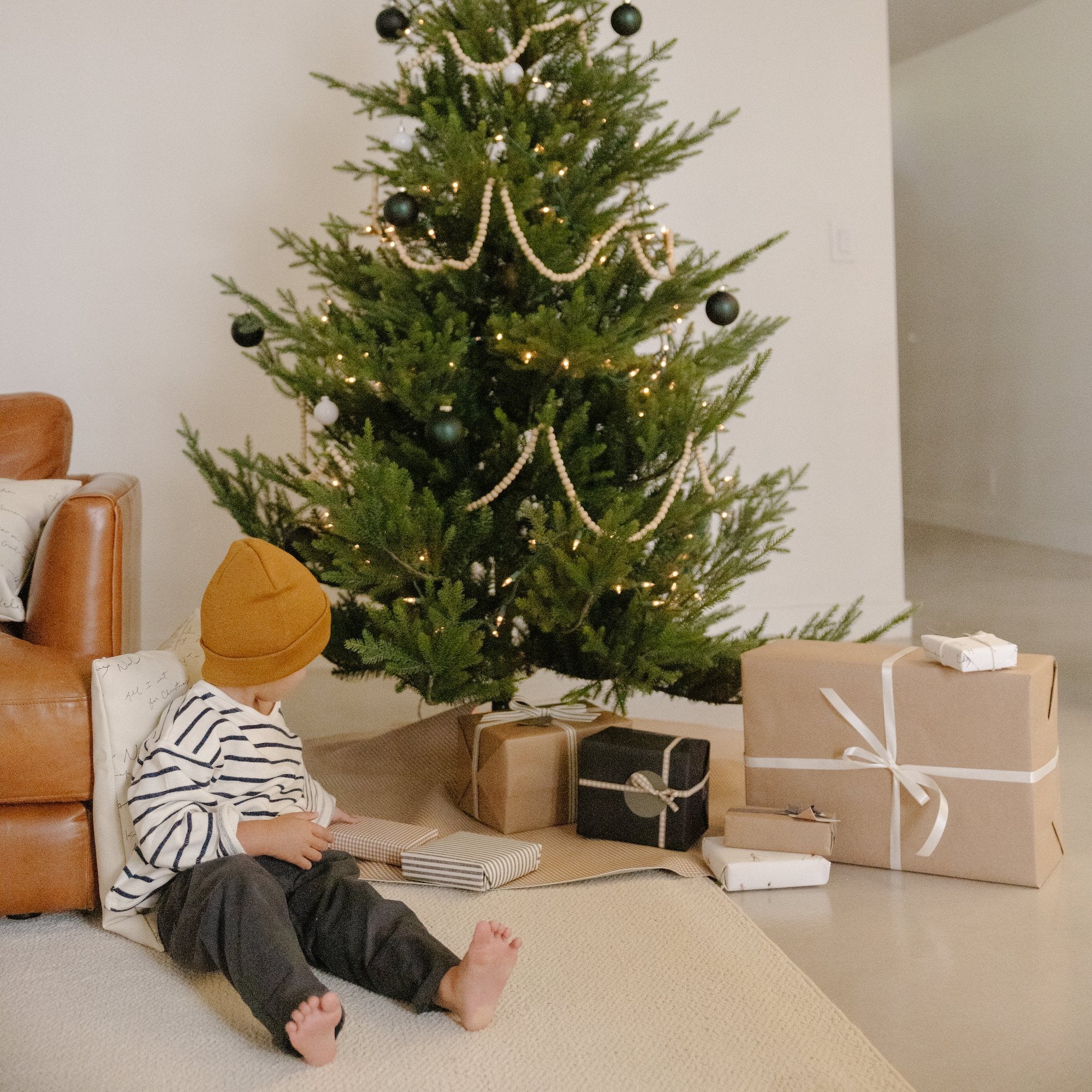 Bronze Check (on sale)@Bronze Check Tree Skirt under tree with a kid nearby