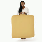 Soleil (on sale) / Square@woman holding up the soleil square floor cushion