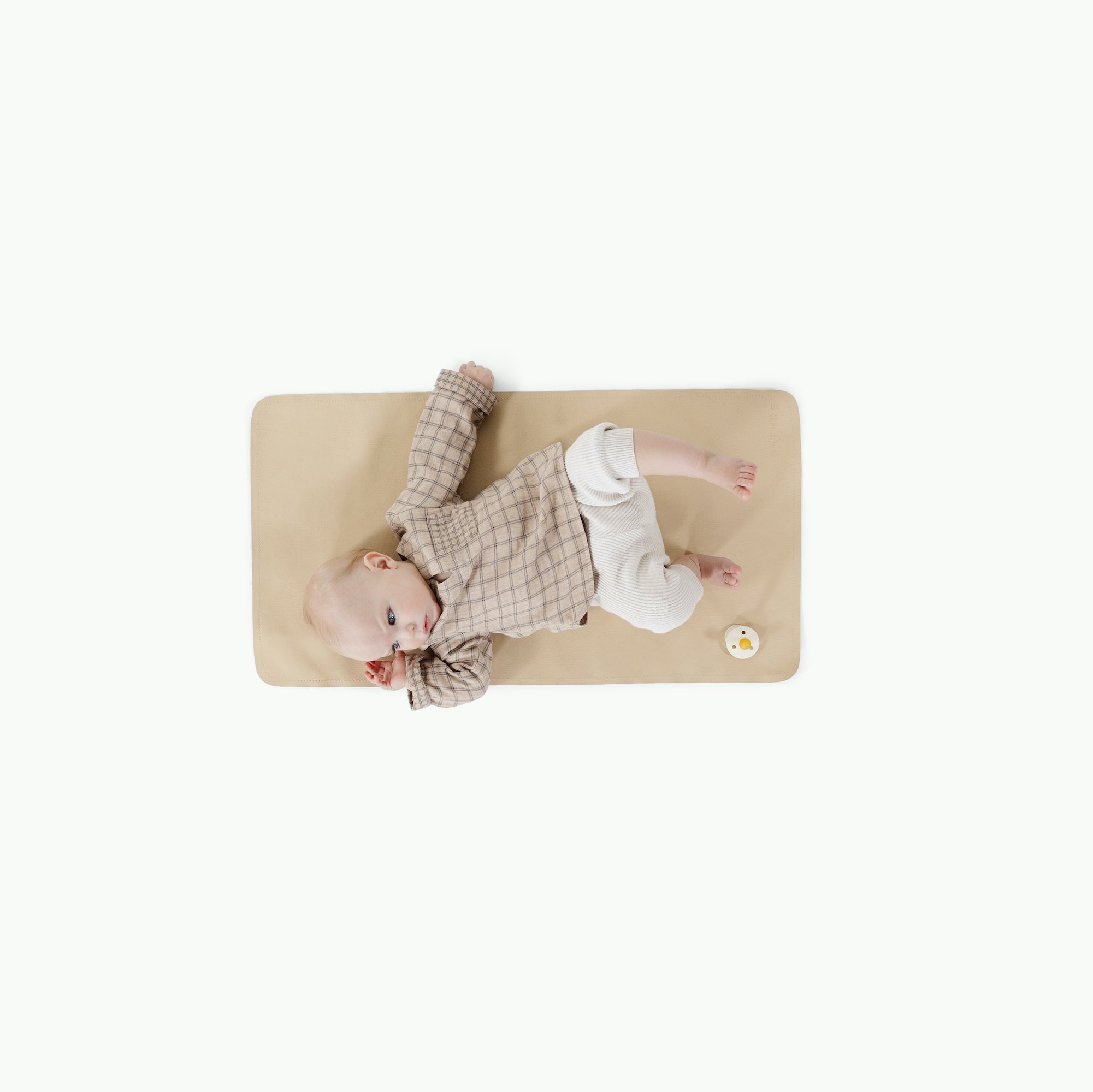 Créme (on sale)@overhead of baby laying on the créme micro+ mat