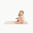 Dinosauria@baby sitting on a mat