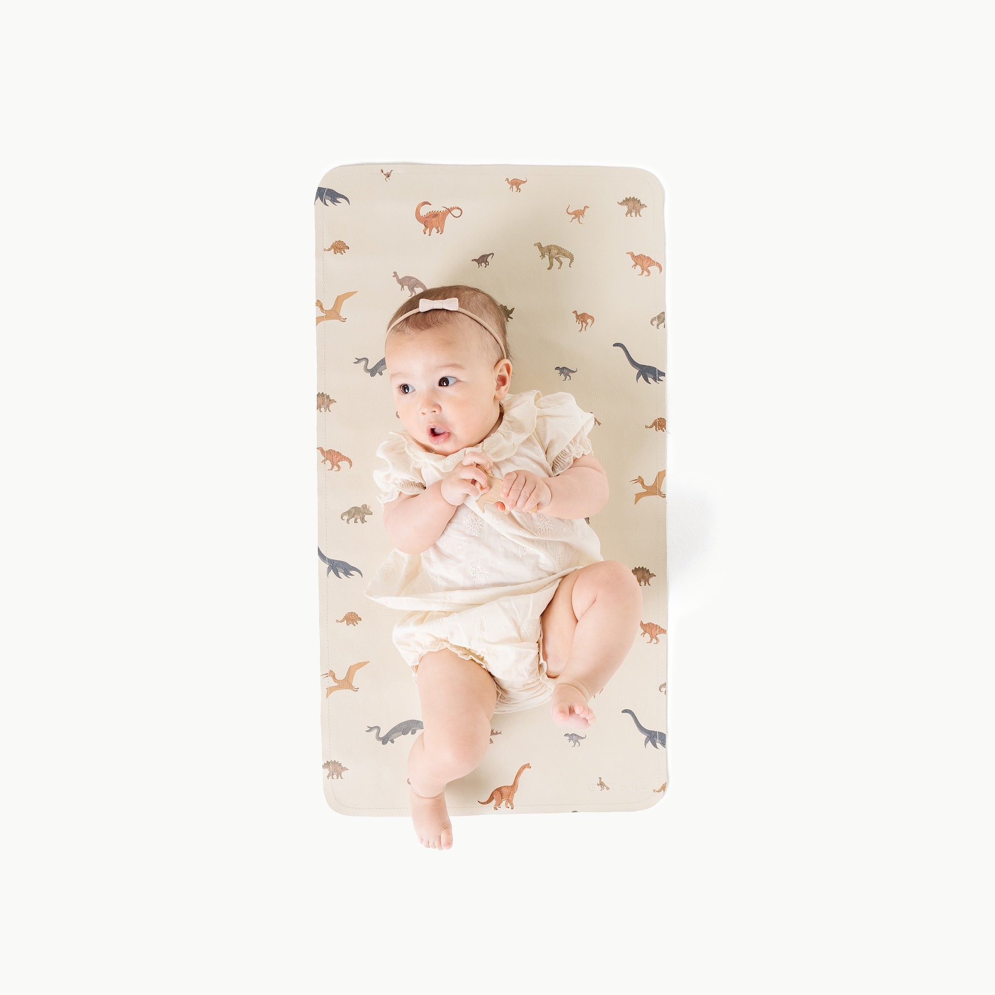 Dinosauria@overhead of baby laying on mat