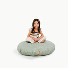 Flora / Circle@little girl sitting on floor cushion