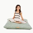 Flora (on sale) / Square@little girl sitting on a floor cushion