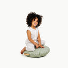 Flora / Circle@little girl sitting on a mini cushion