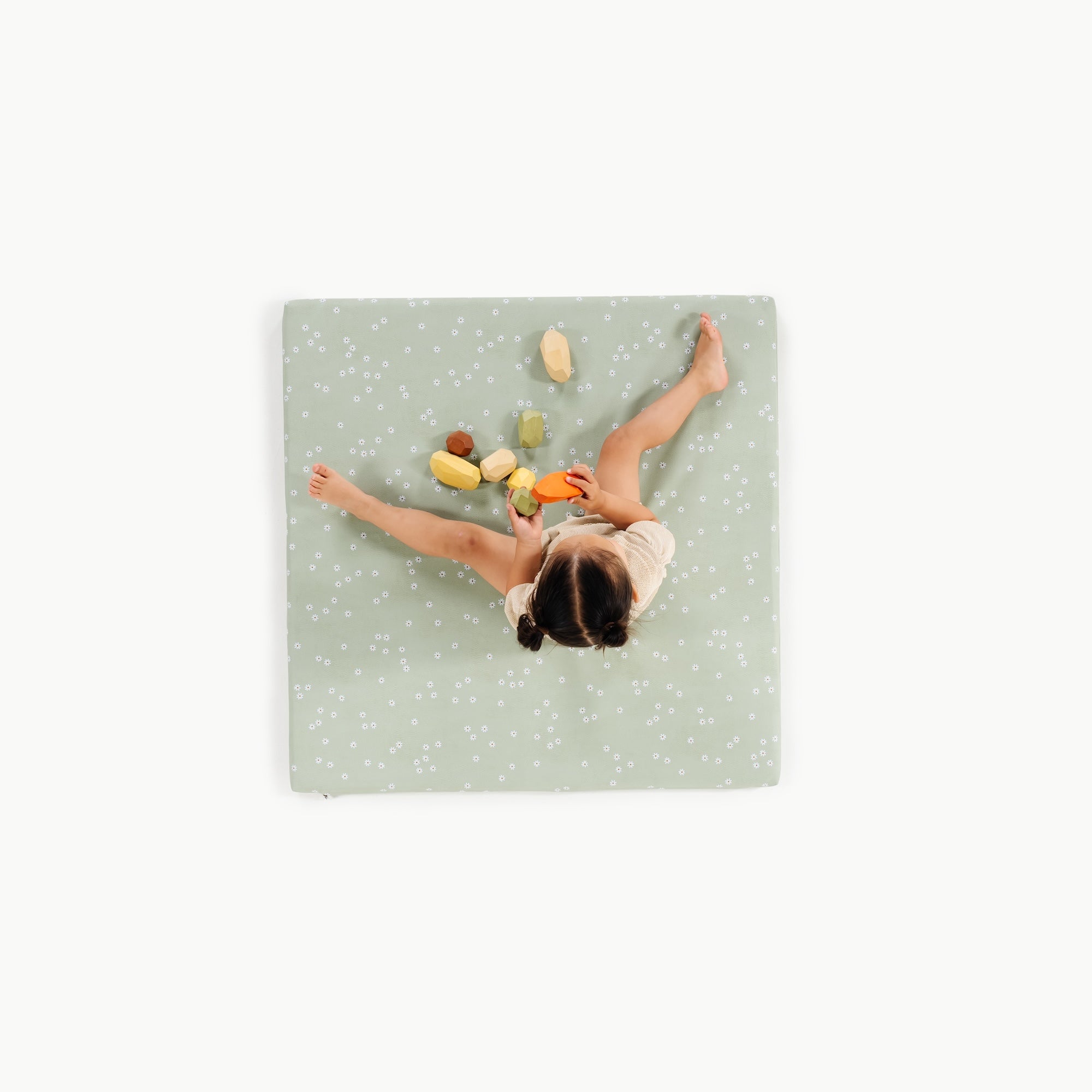 Flora / Square@overhead of little girl playing on padded mat