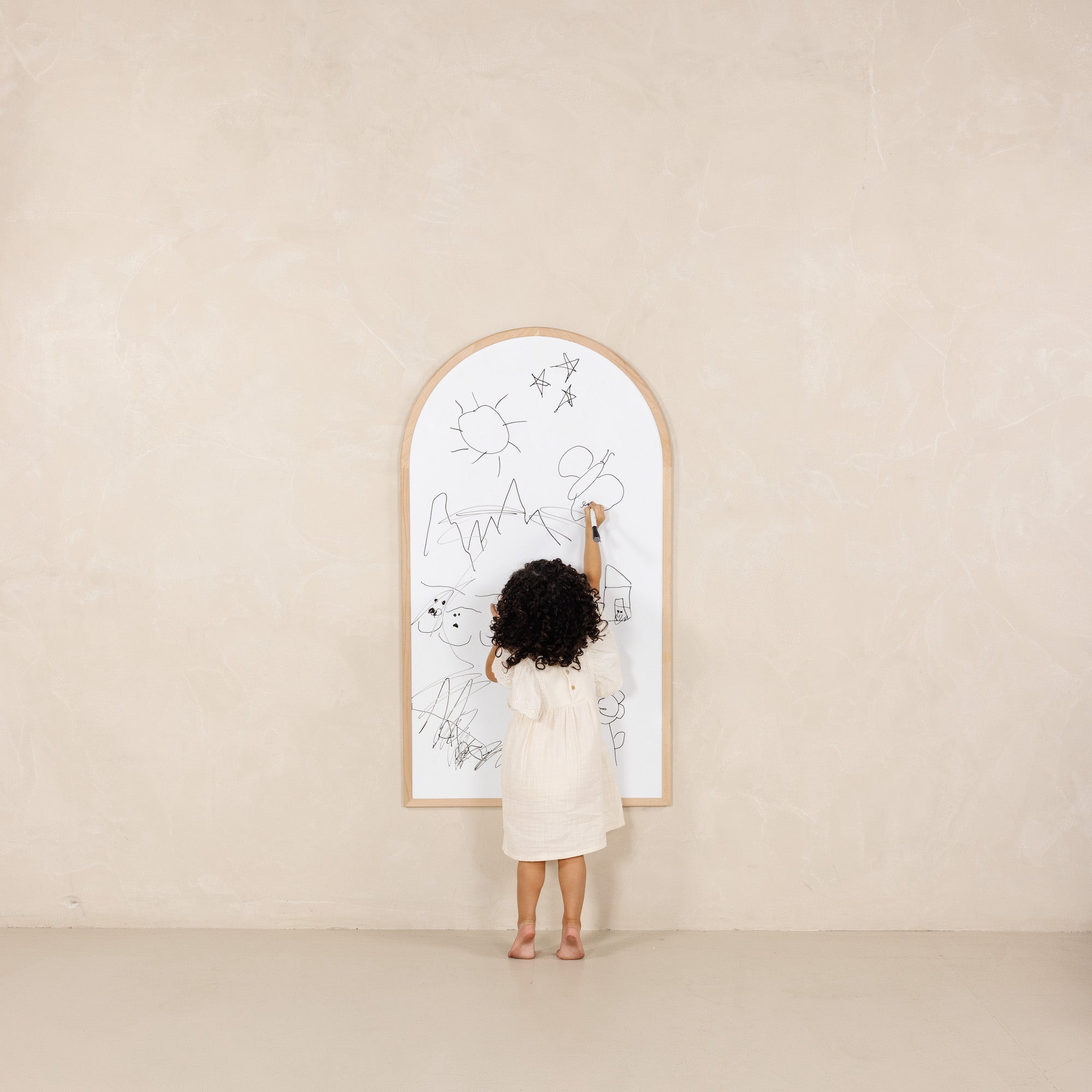 Beech@Kid drawing on the whiteboard side of the Chalkboard hanging on a wall