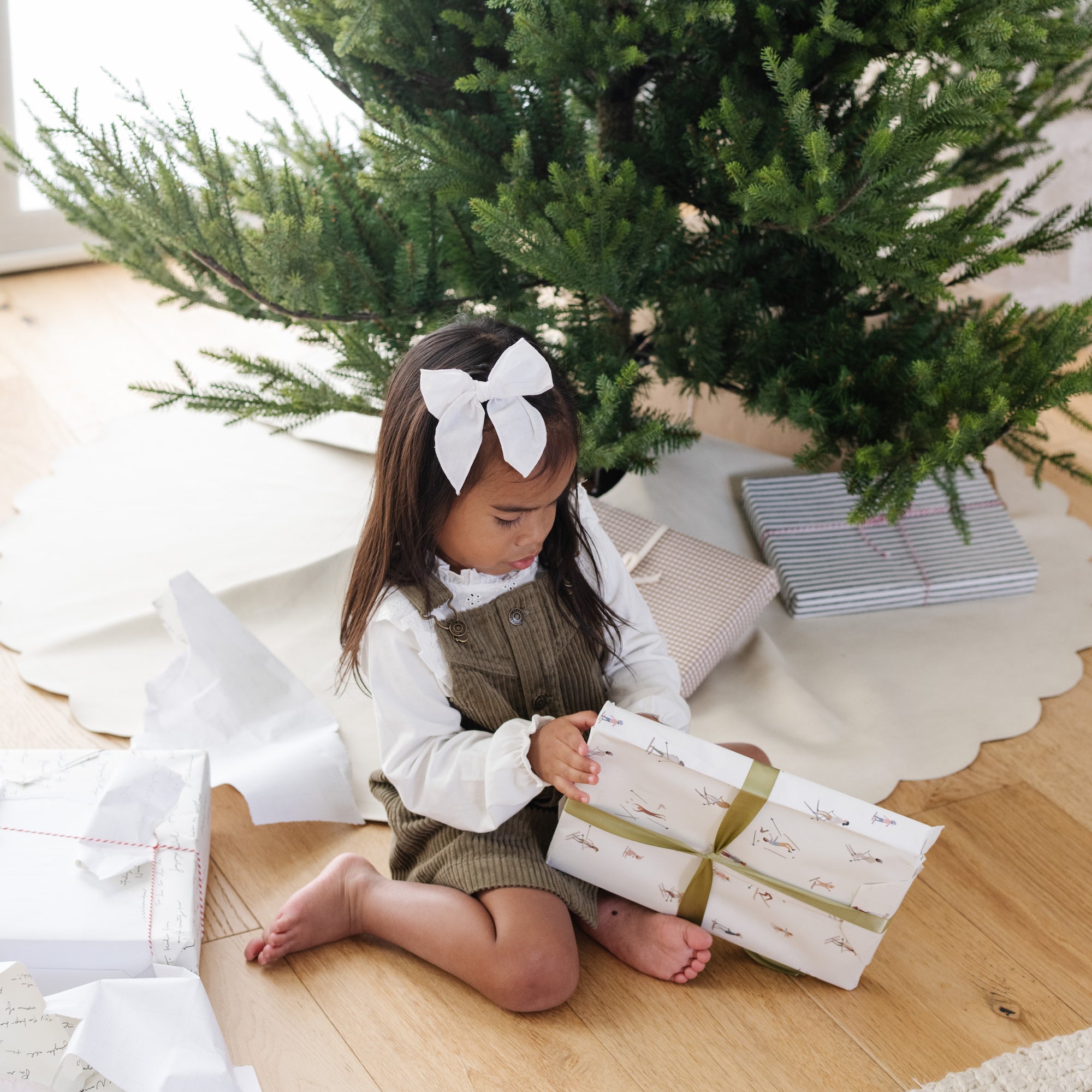 Ivory Scallop (on sale)@Kid opening gift near tree with Ivory Scallop Tree Skirt under it