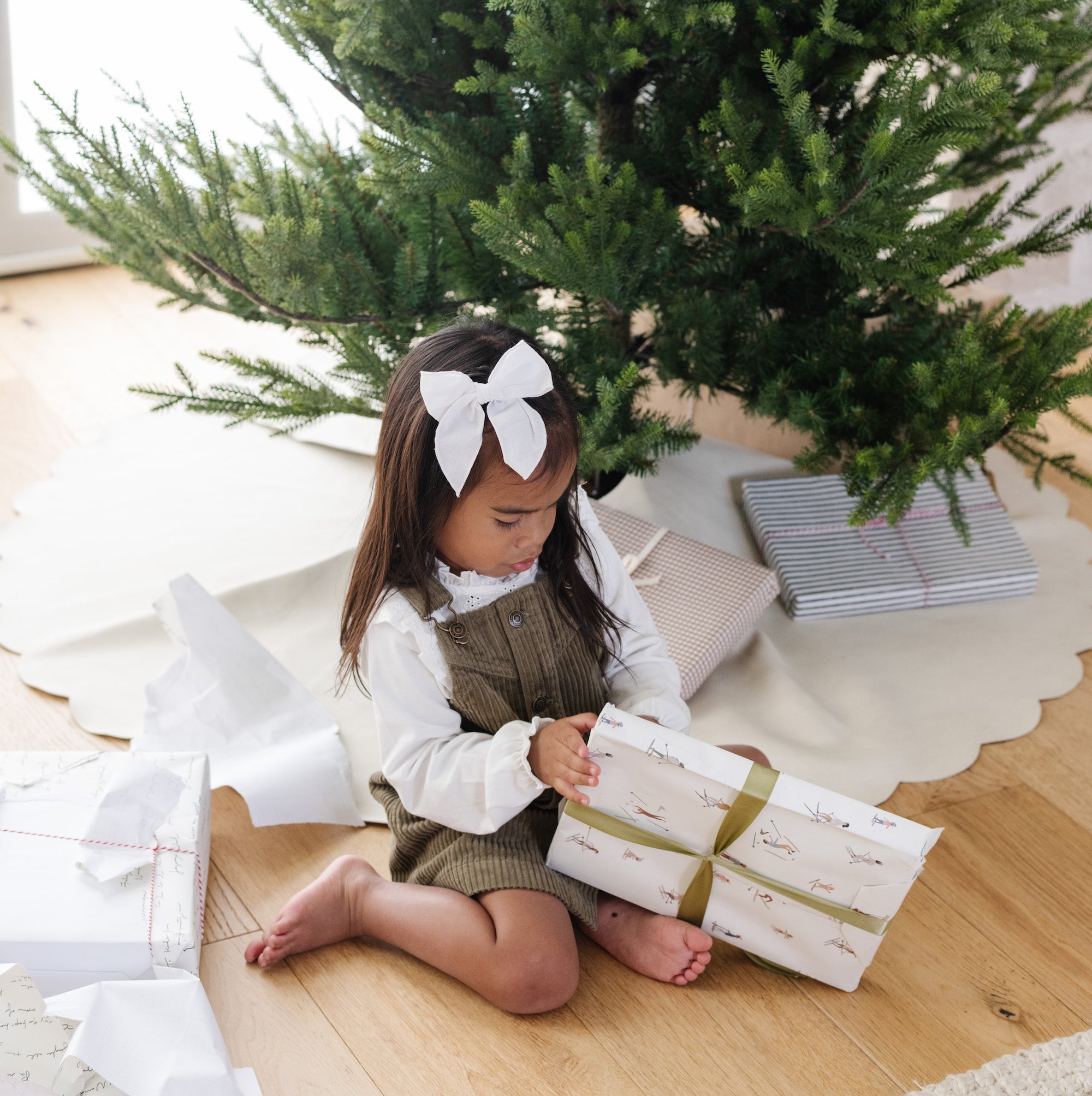 Ivory Scallop (on sale)@Kid opening gift near tree with Ivory Scallop Tree Skirt under it