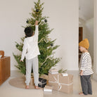 Bronze Check (on sale)@Bronze Check Tree Skirt under tree with a kids nearby