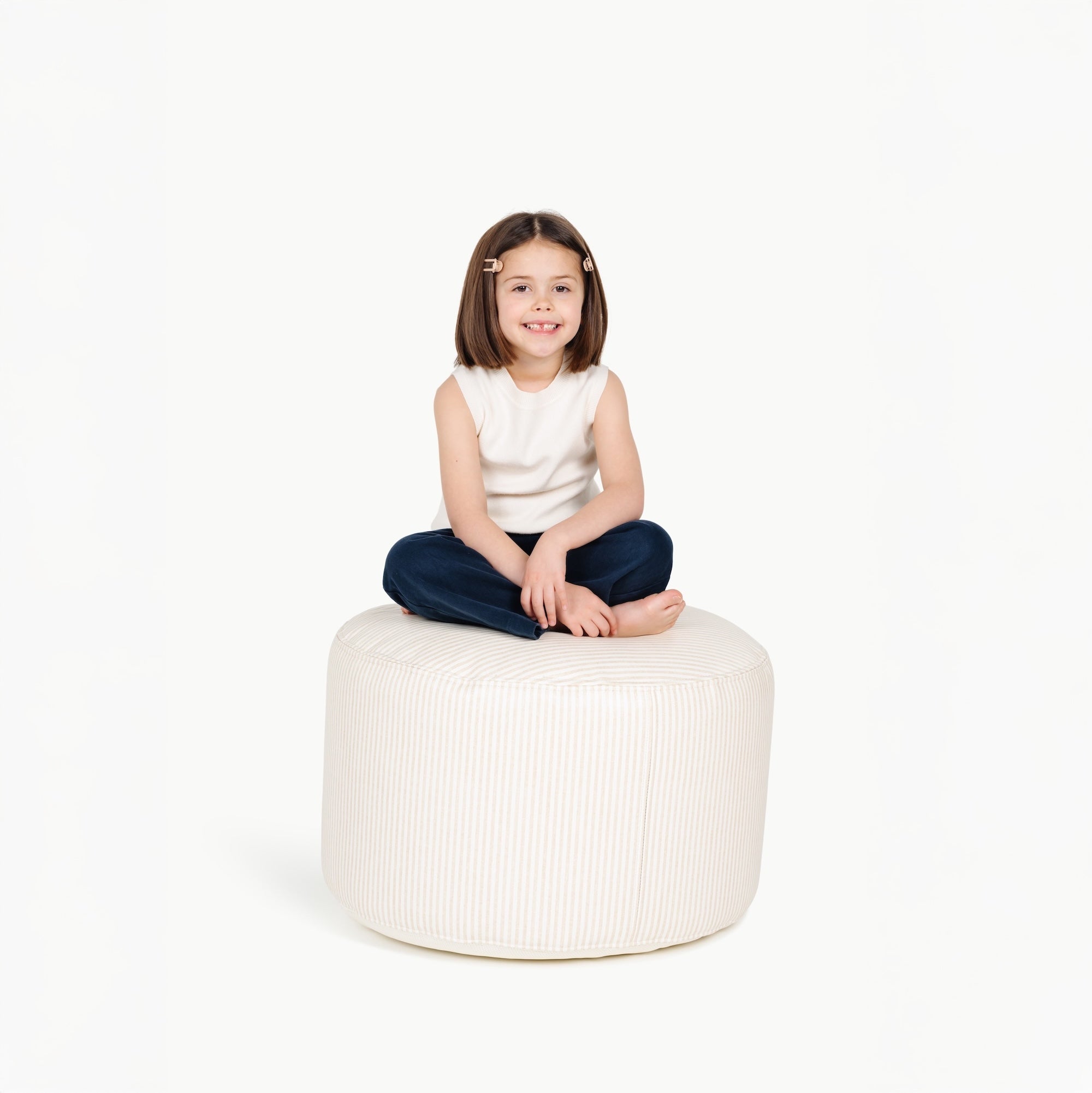 Pinstripe@little girl sitting on a circle pouf
