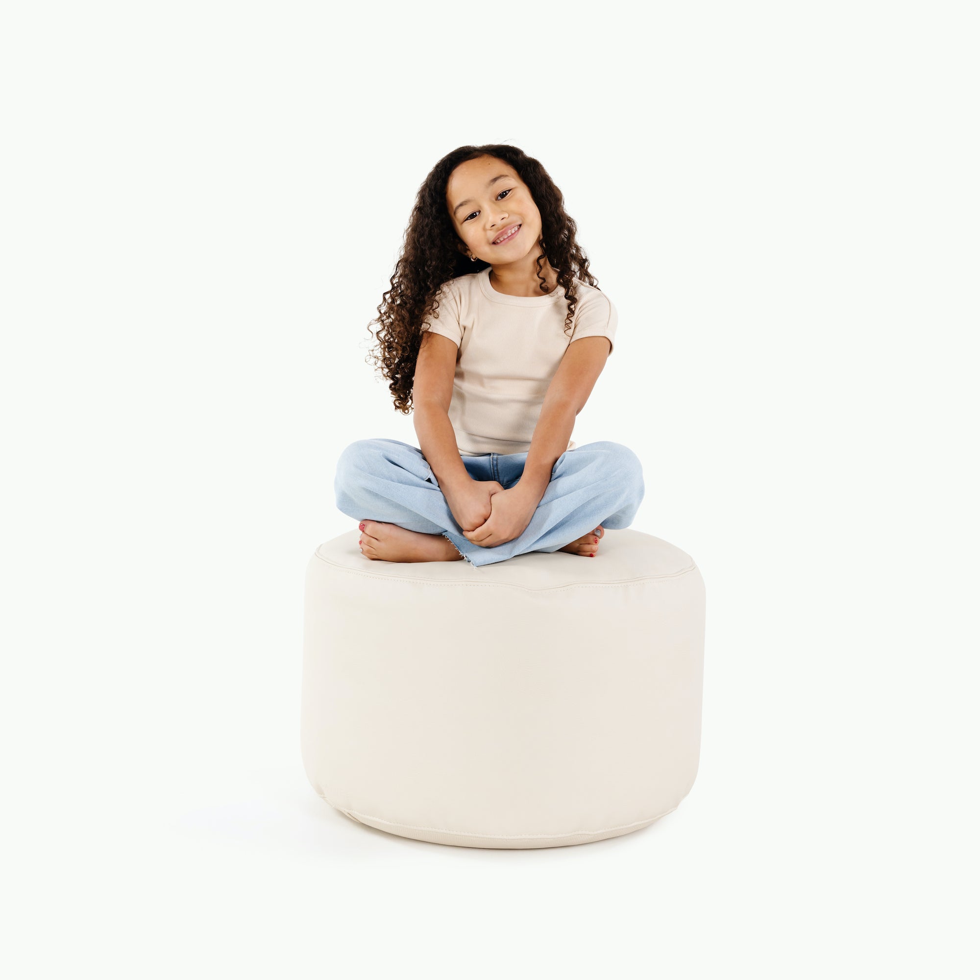 Ivory@kid sitting on the ivory circle pouf