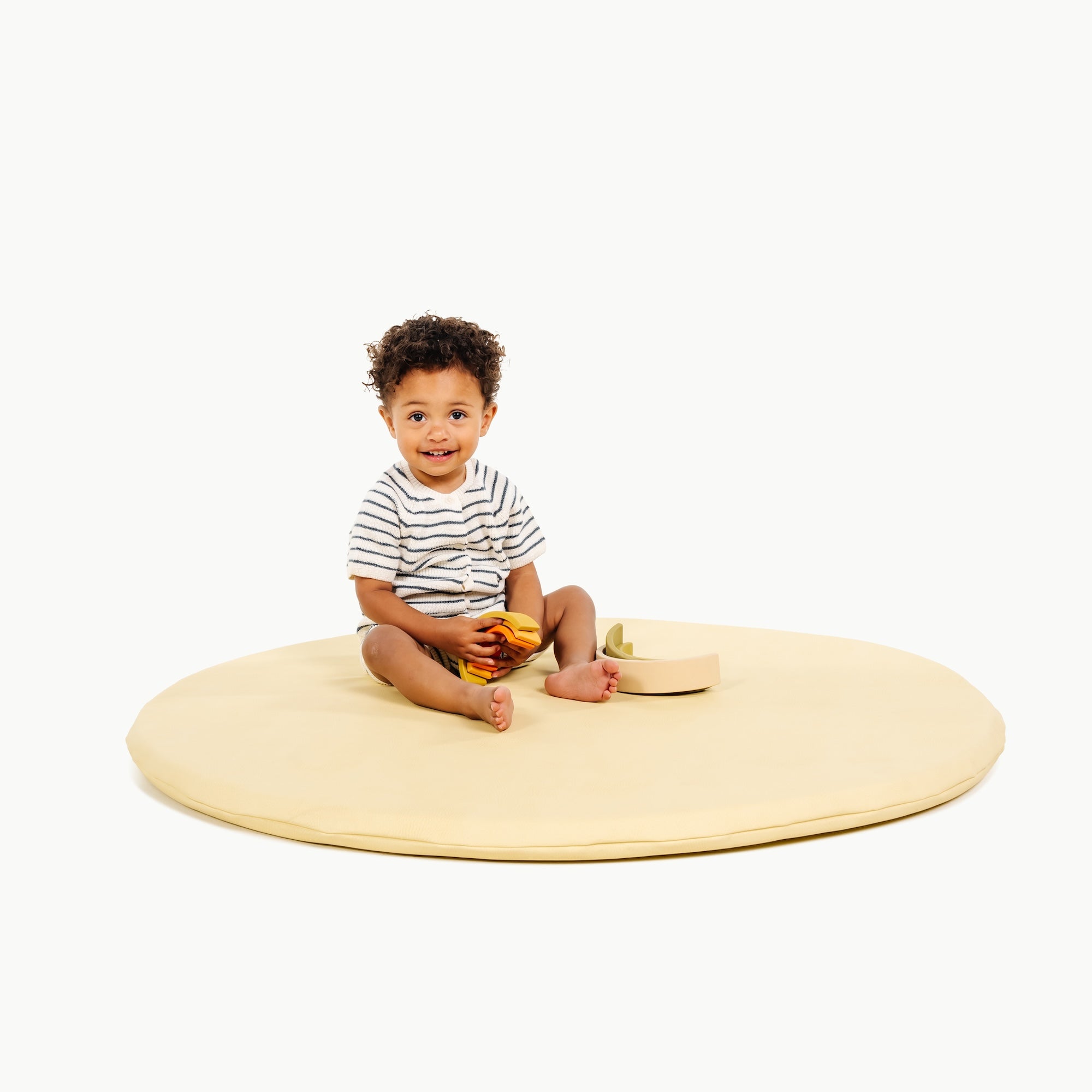 Mellow / Circle@little boy sitting on padded mat