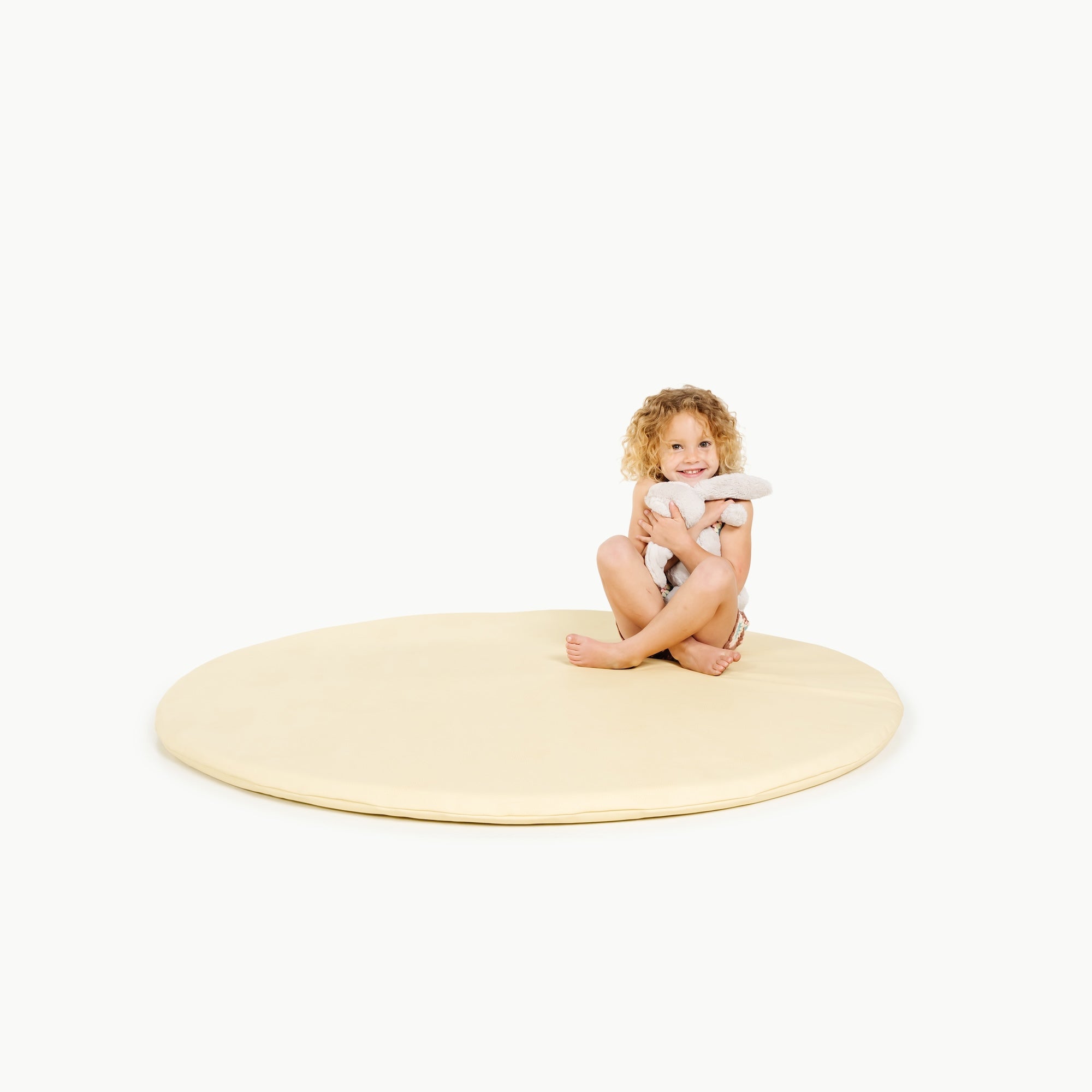 Mellow@little girl sitting on padded mat