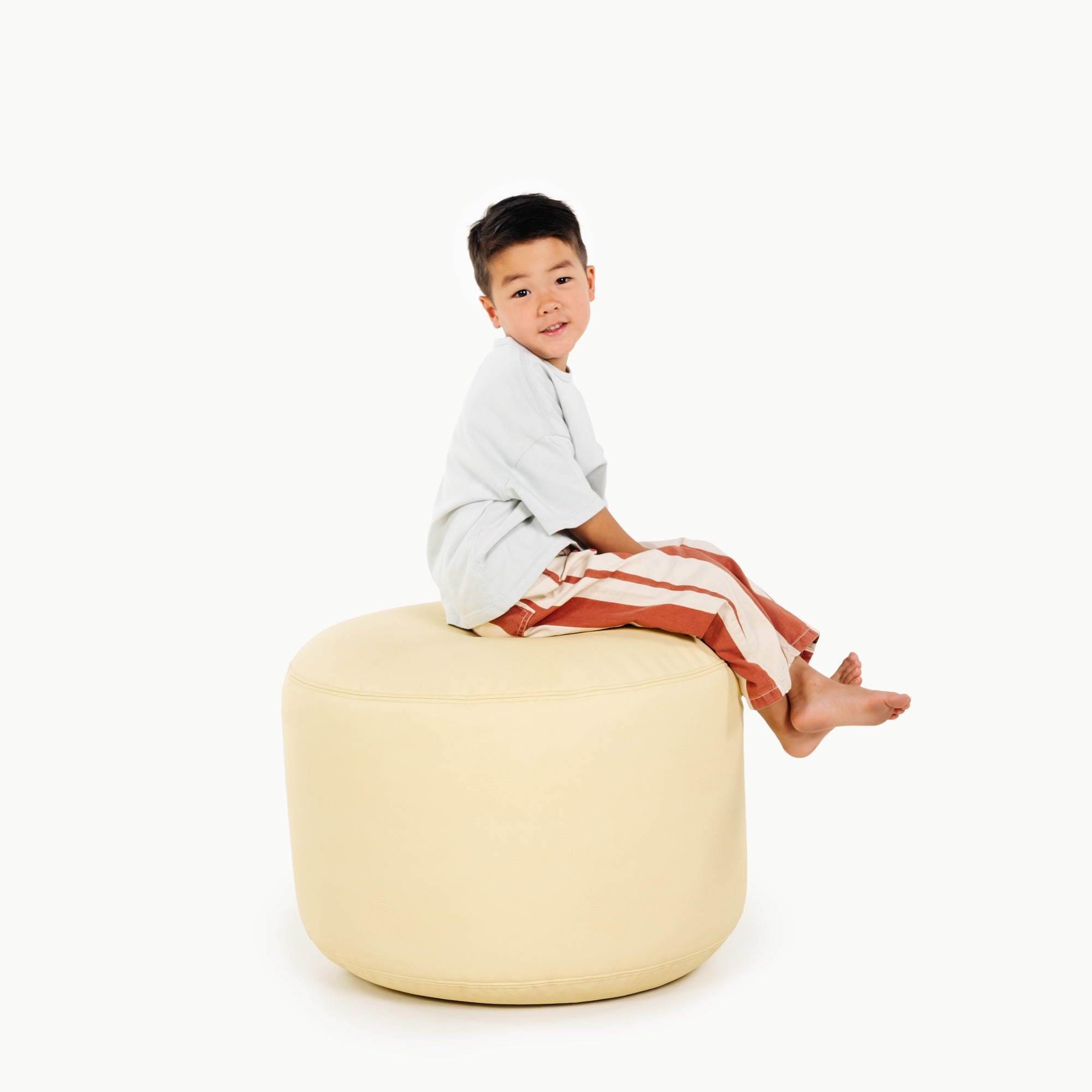 Mellow@little boy sitting on pouf