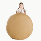 Ochre (on sale) / Circle@Kid holding the Ochre Circle Floor Cushion