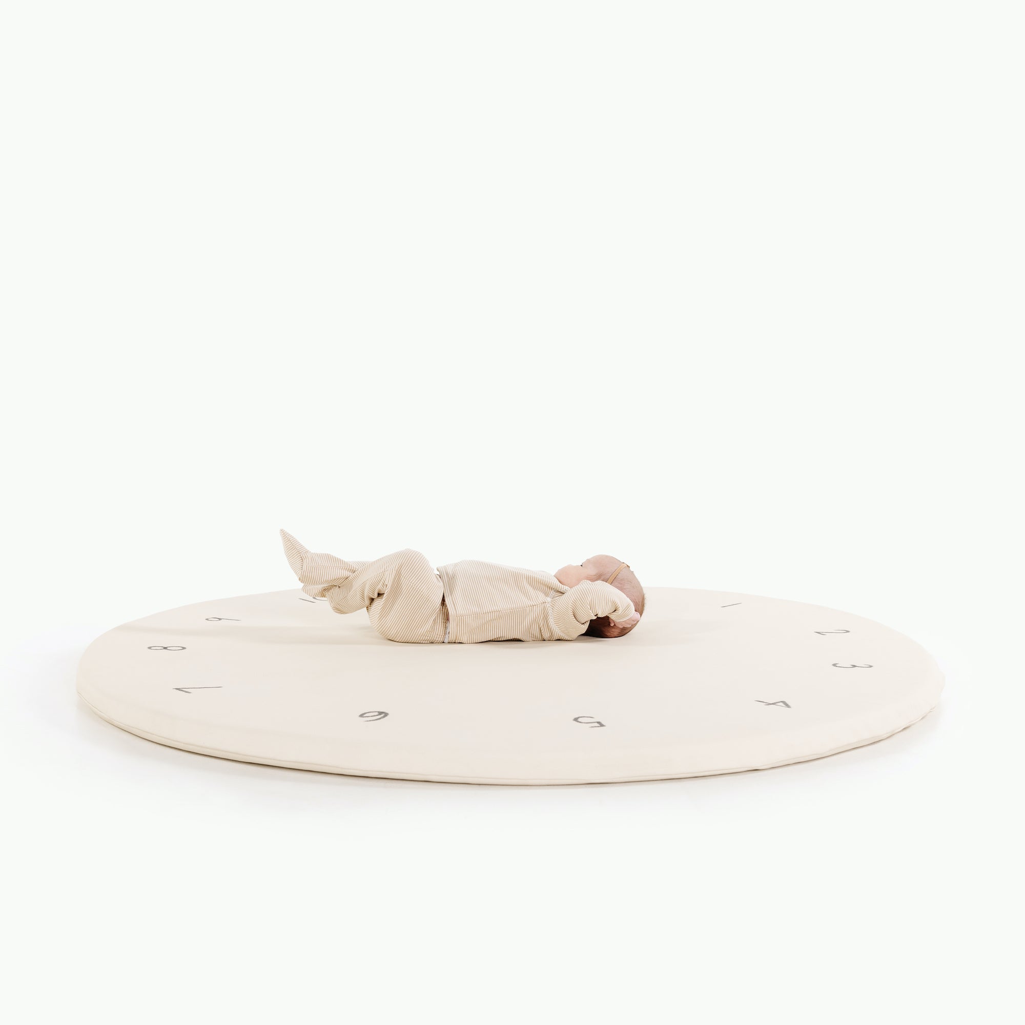 Milestones (on sale)@Baby laying on padded midi circle