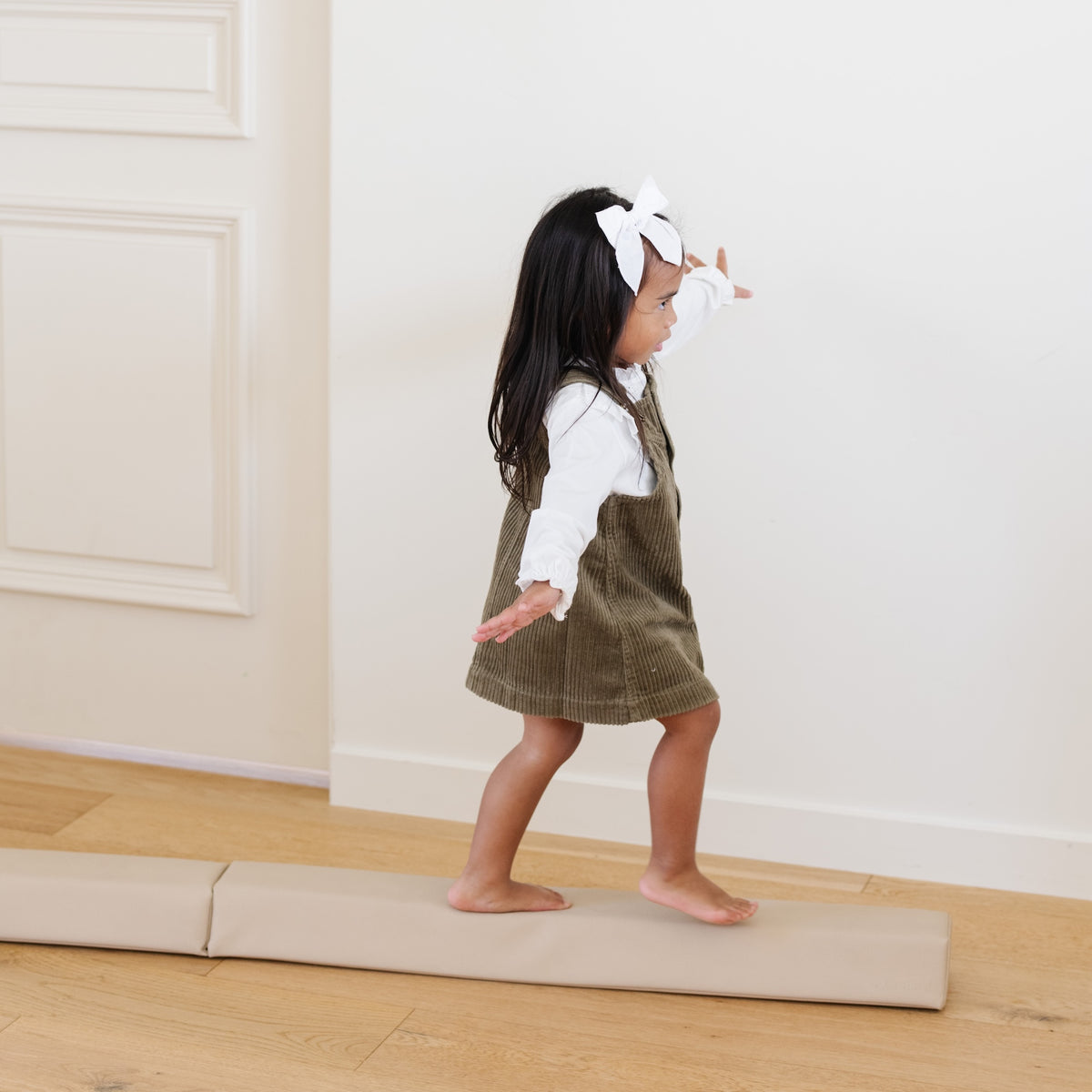 Millet@lifestyle image of little girl playing on balance beam