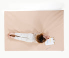 Pomelo (on sale)@overhead of kid laying on the pomelo padded midi+ mat