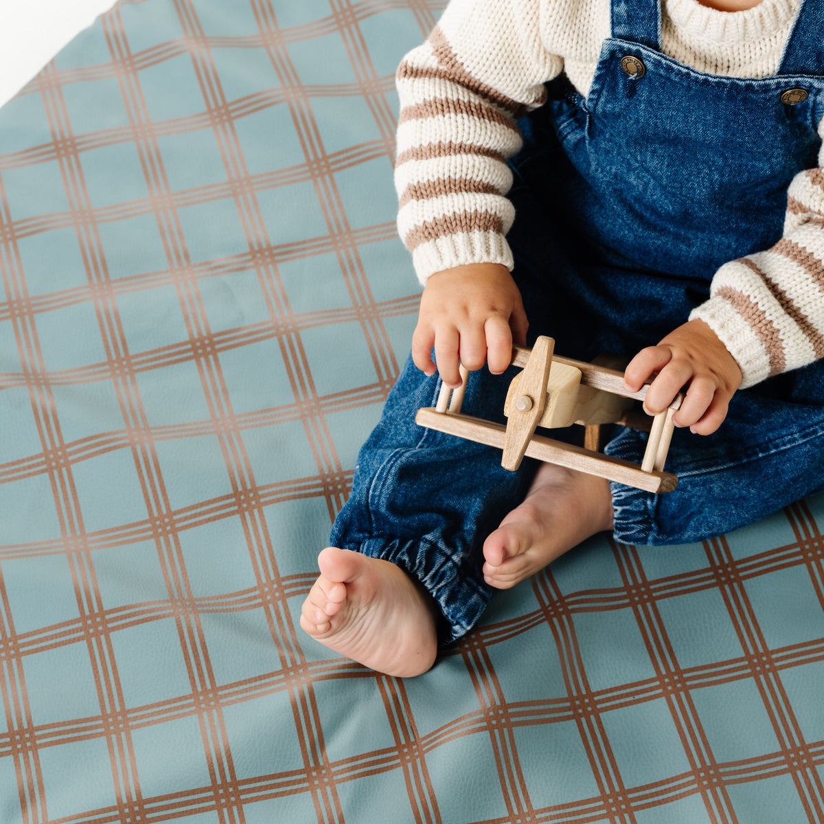 Rustic Plaid@overhead detail of little boy playing on padded mini