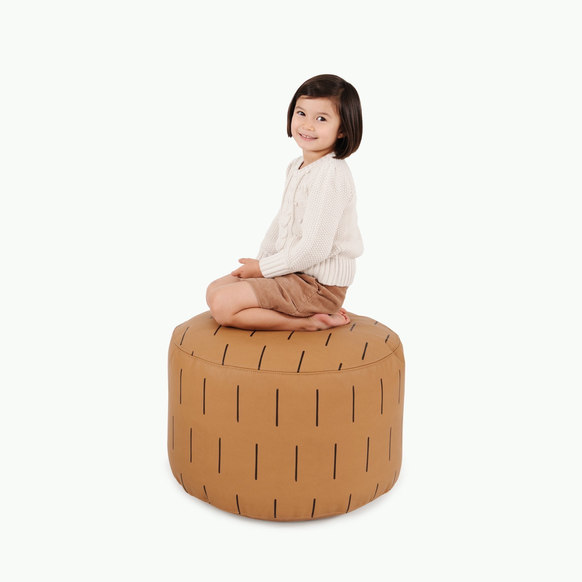 Camel Dash (on sale)@Kid sitting on the Camel Dash Circle Pouf