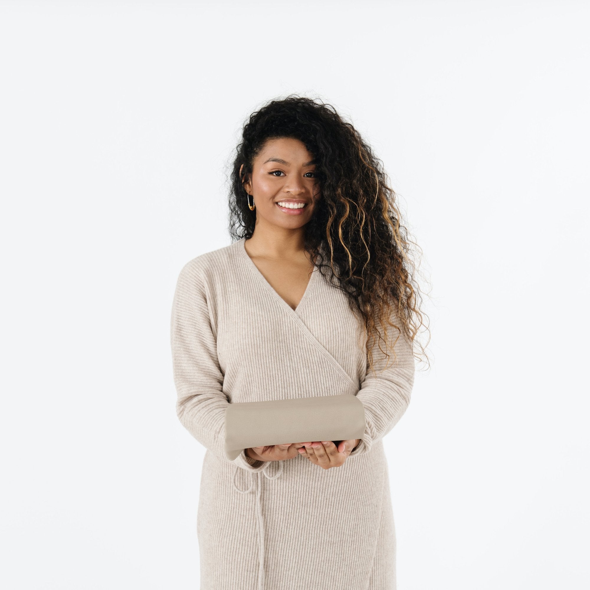 Ember (on sale)@Woman holding a folded Ember Midi+ Mat