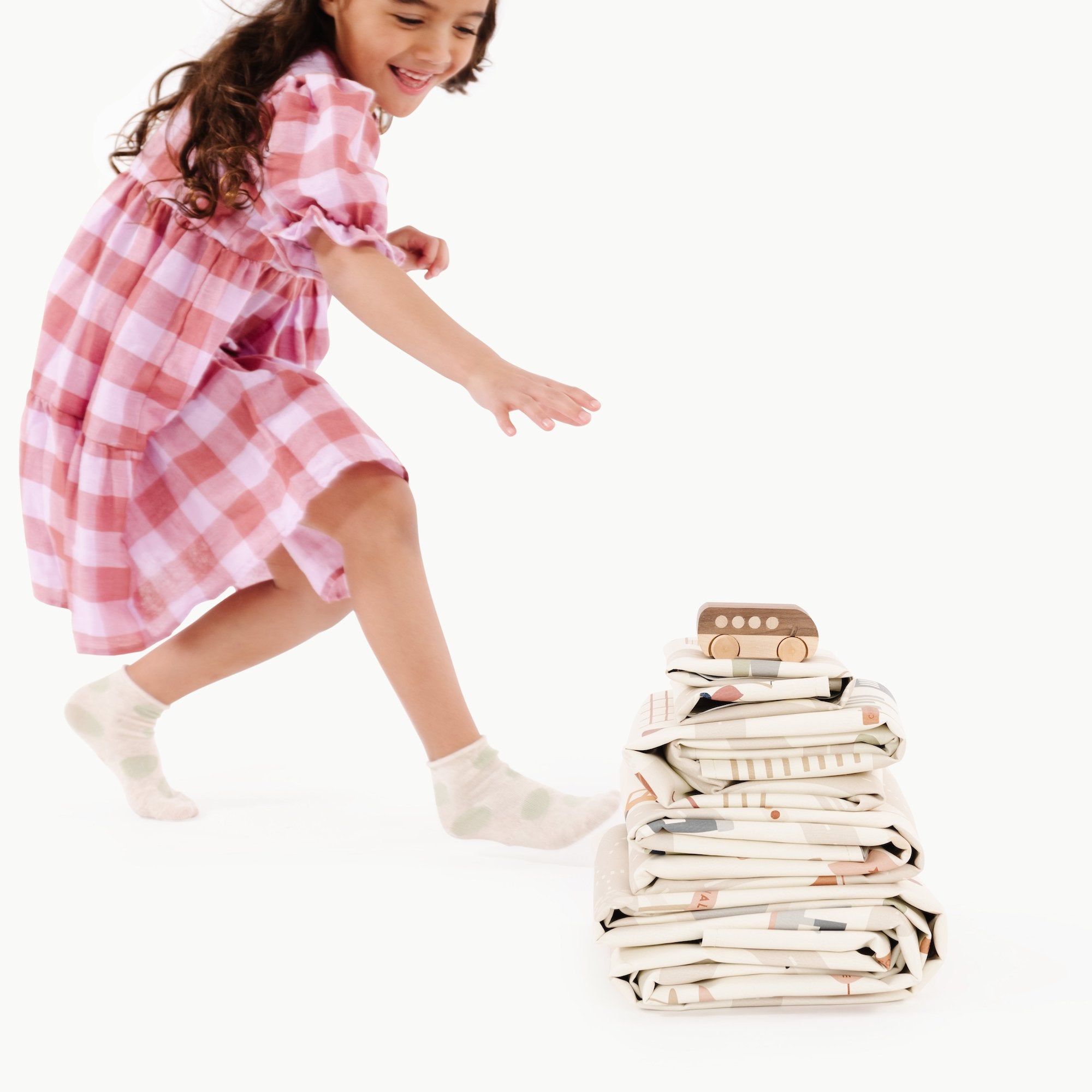 Uptown@Kid running towards stack of playmats