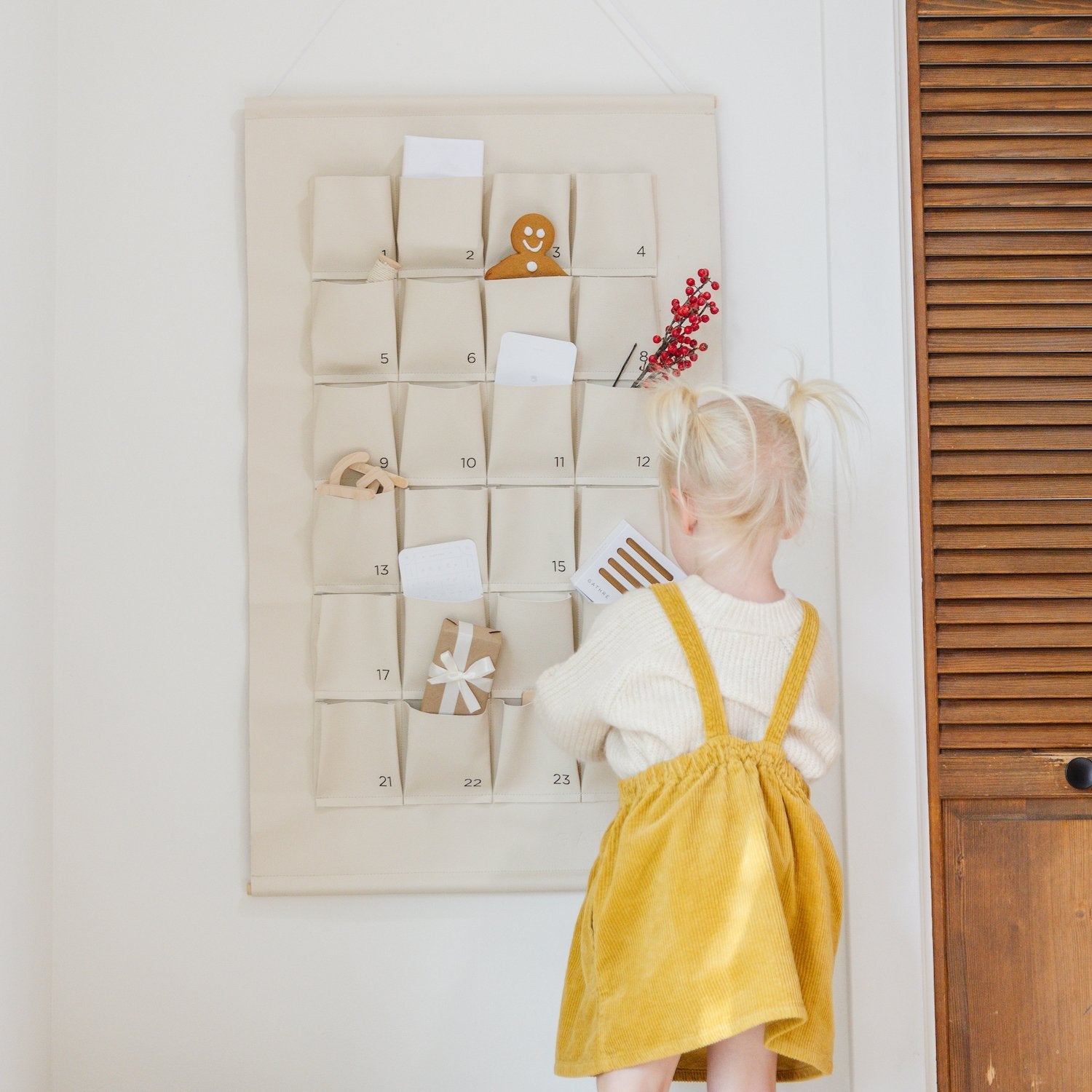 Ivory@Kid standing near the Small Ivory Advent Calendar on the wall