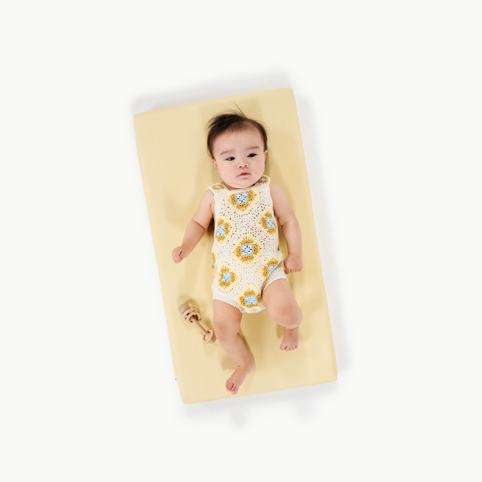 Mellow@overhead of a baby on a padded micro+