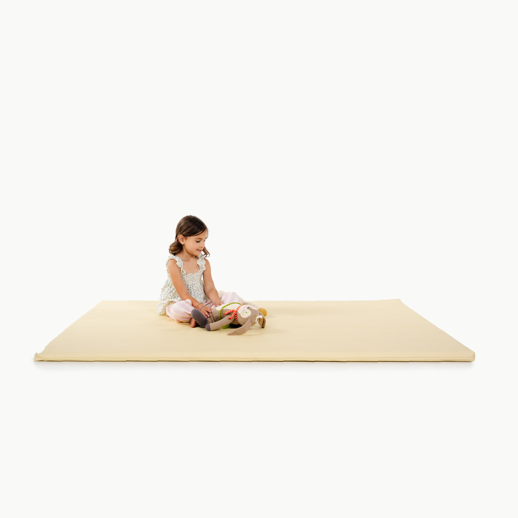 Mellow@little girl sitting on padded mat