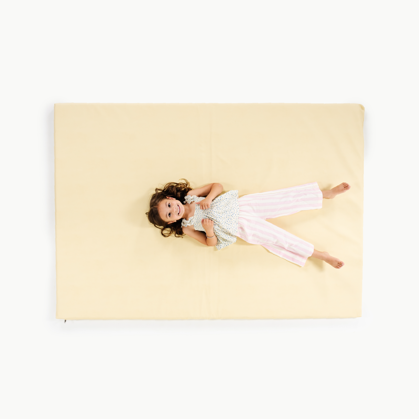 Mellow@overhead of little girl sitting on padded mat