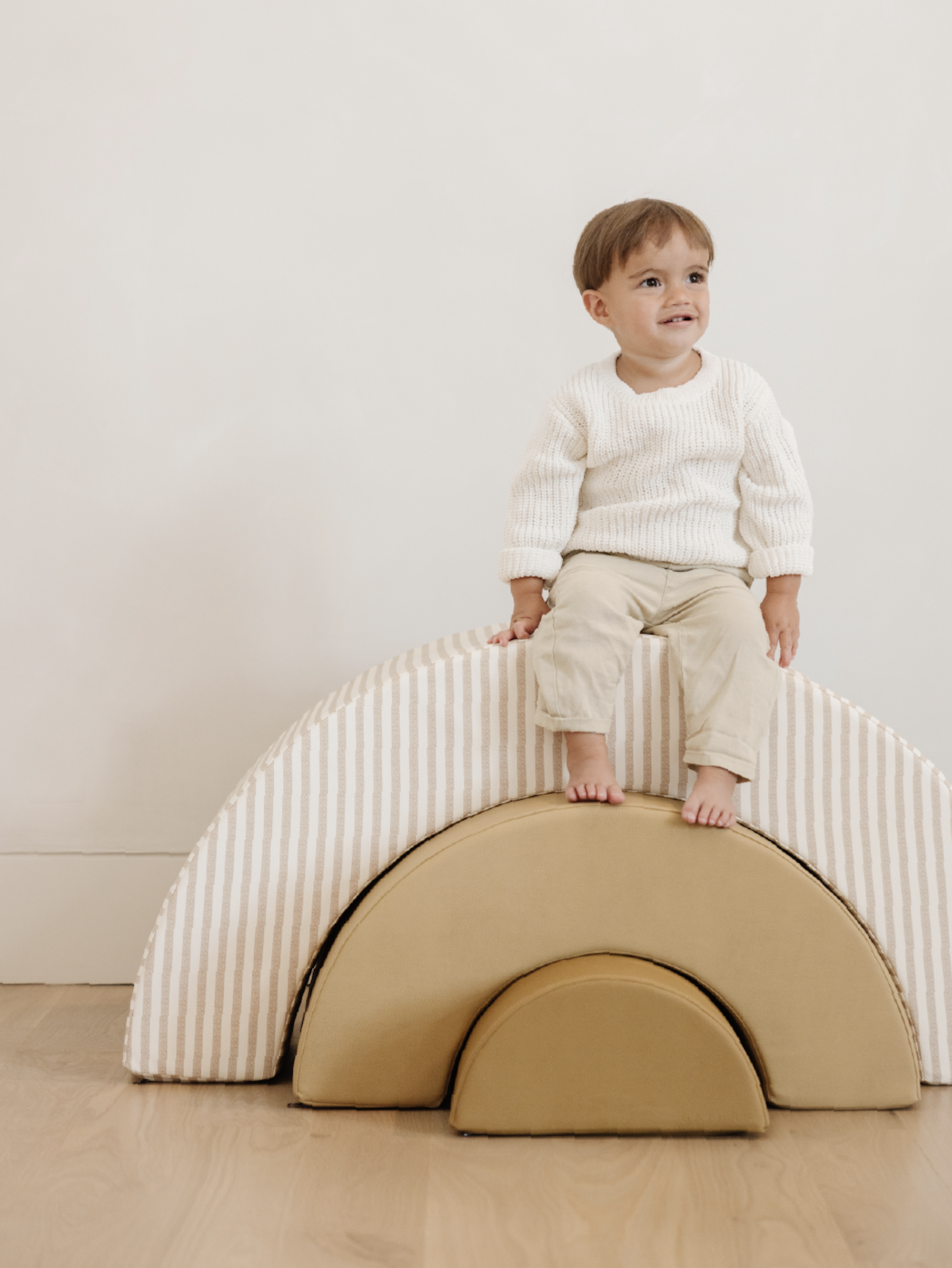 Little kid sitting on the Arc Playset.