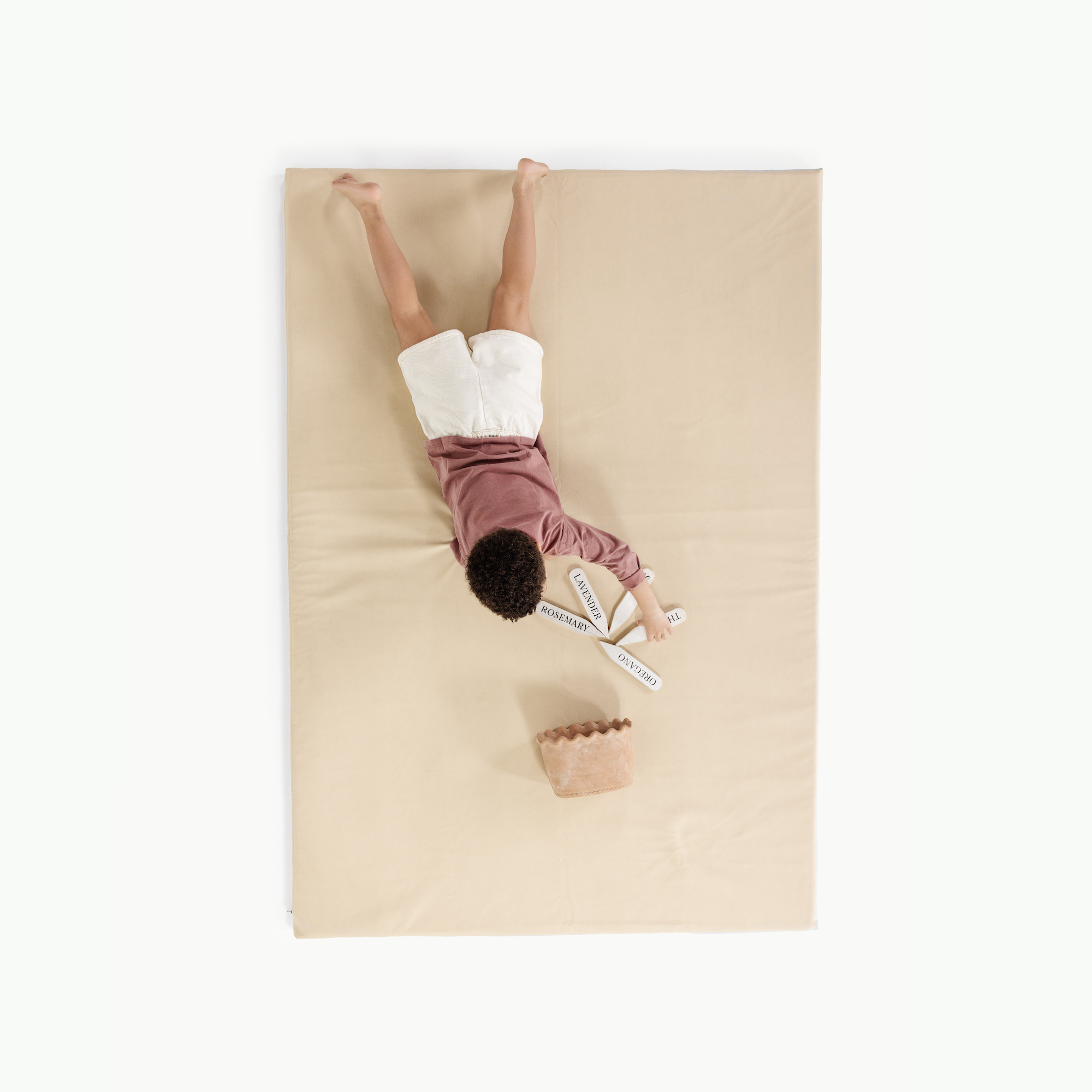 Créme (on sale)@overhead of little boy on padded mat