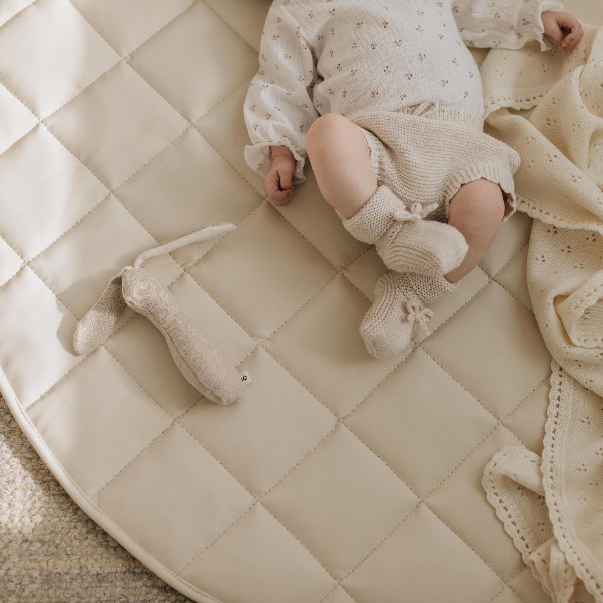 overhead of baby on a quilted mini mat
