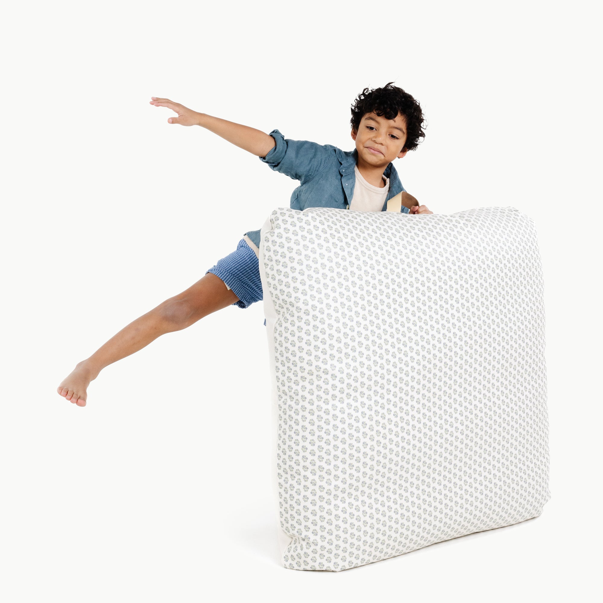 Meadow / Square@kid holding the meadow square floor cushion