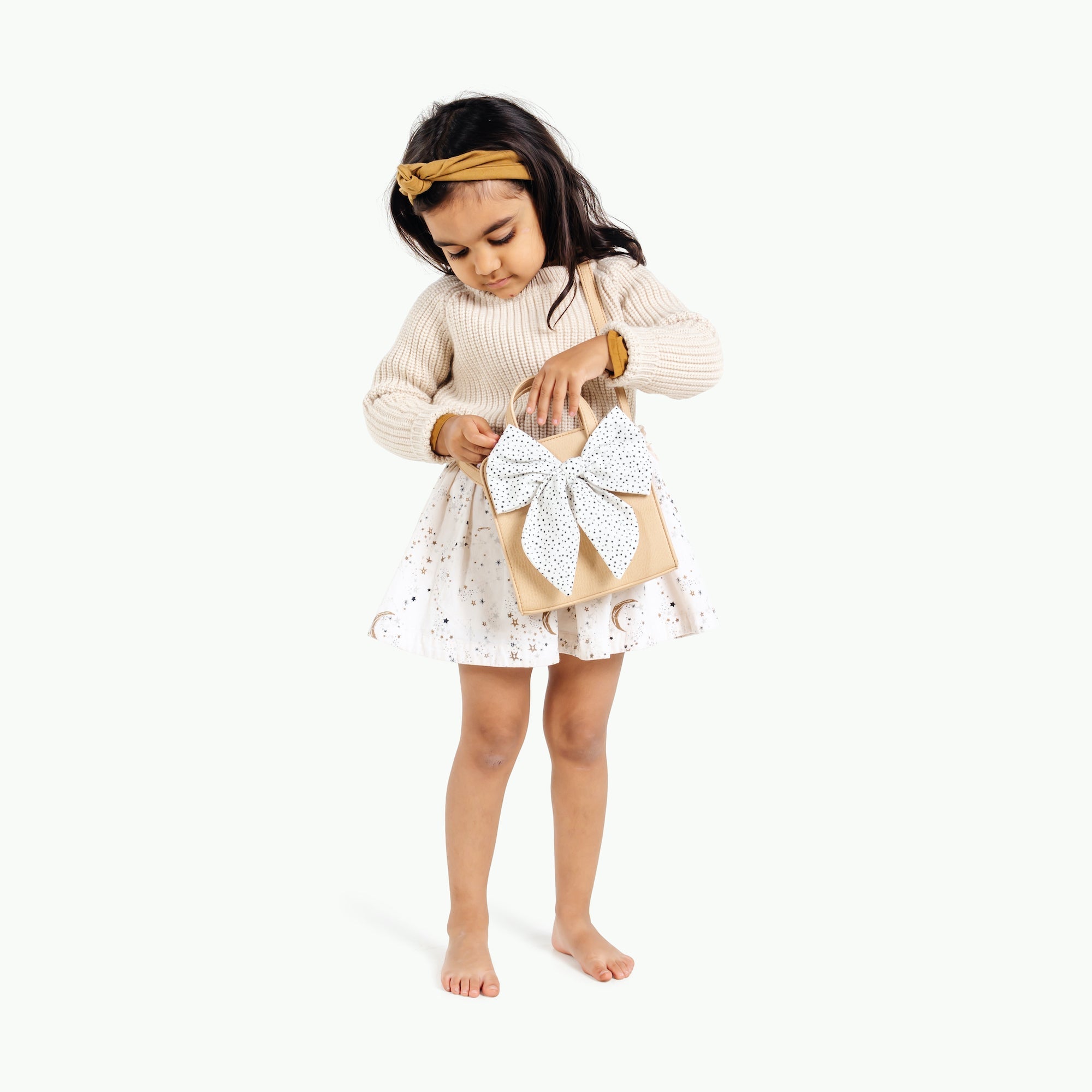 Untanned@little girl playing with the untanned children's purse