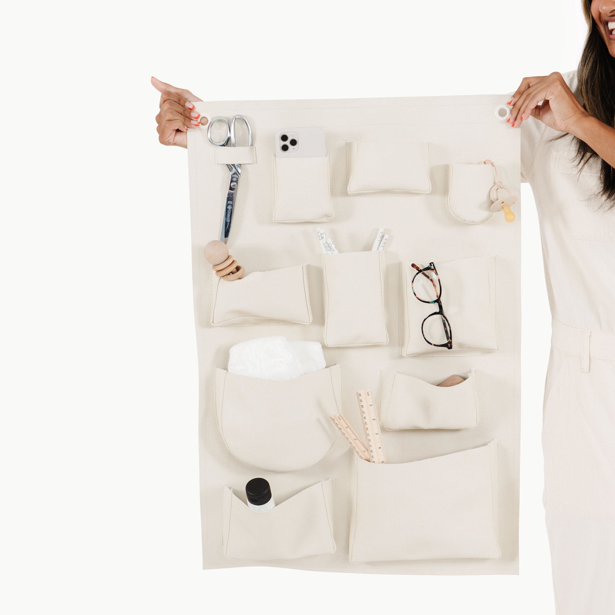 Ivory@Items in pockets of Wall Tidy, held by a woman