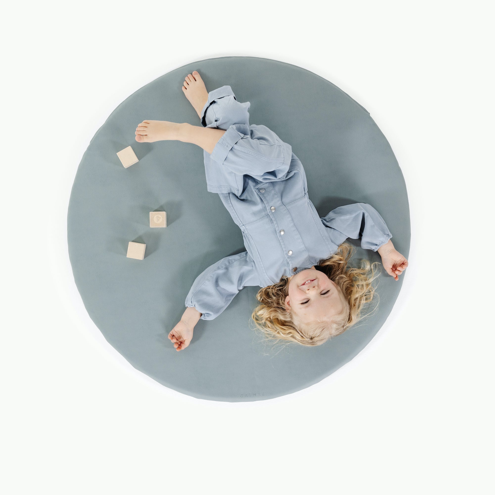 Amalfi / Circle@overhead of little girl playing on padded mat