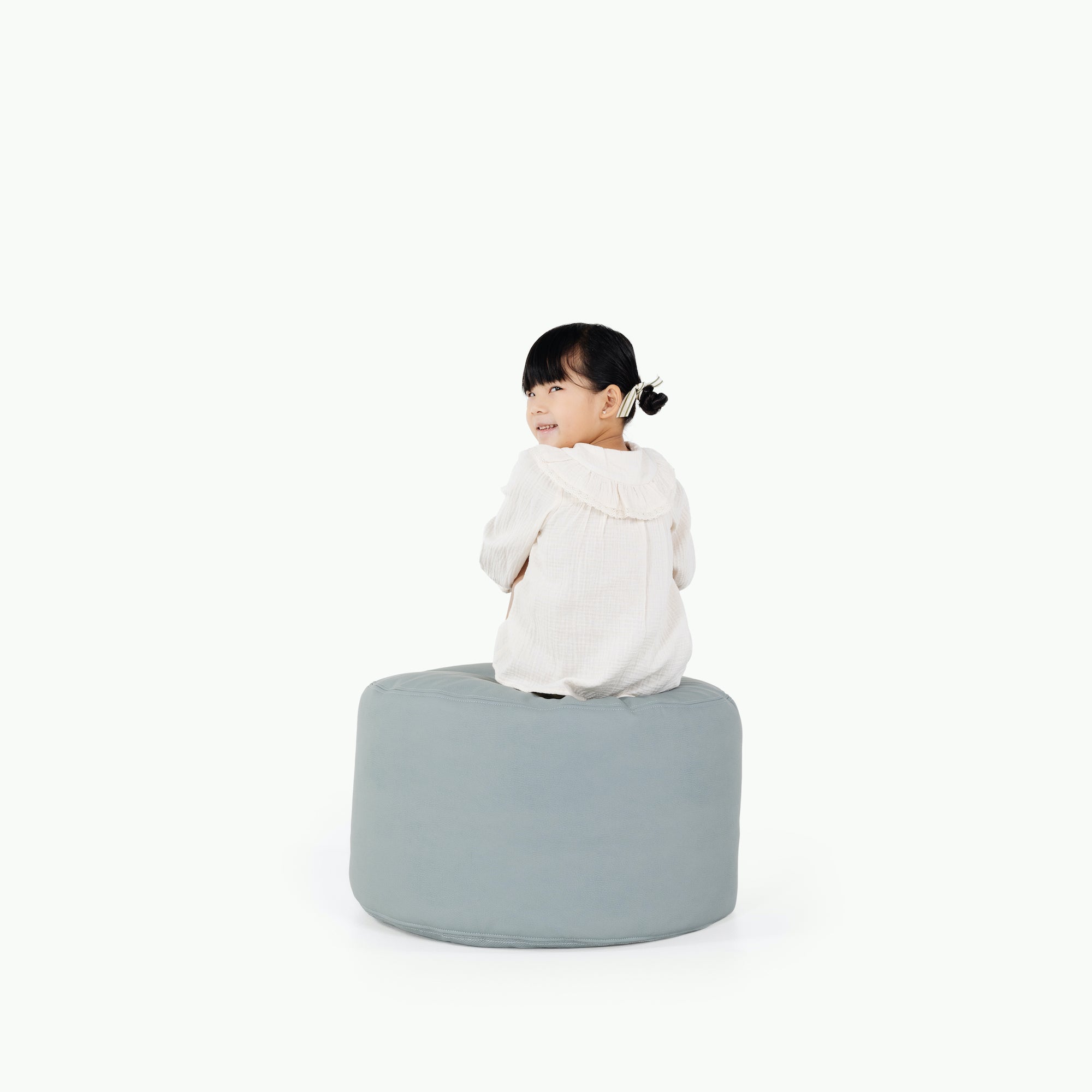 Amalfi / Circle@little girl sitting on pouf