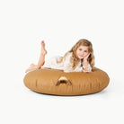 Camel / Circle@little girl laying on floor cushion