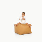 Camel / Square@little boy sitting on the Camel Square Pouf