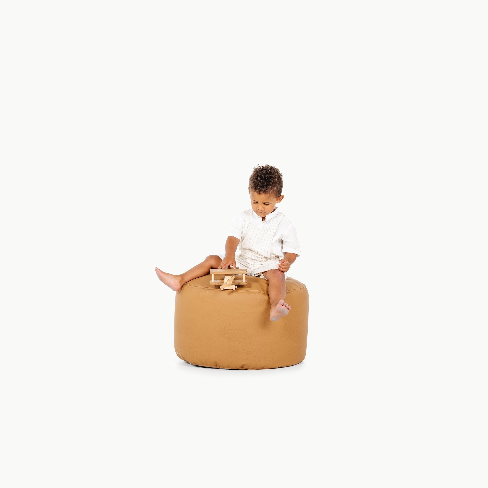 Camel / Circle@little boy sitting on the Camel Circle Pouf