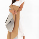 Fog • Camel (on sale)@woman holding up the Fog • Camel Midi Square Mat