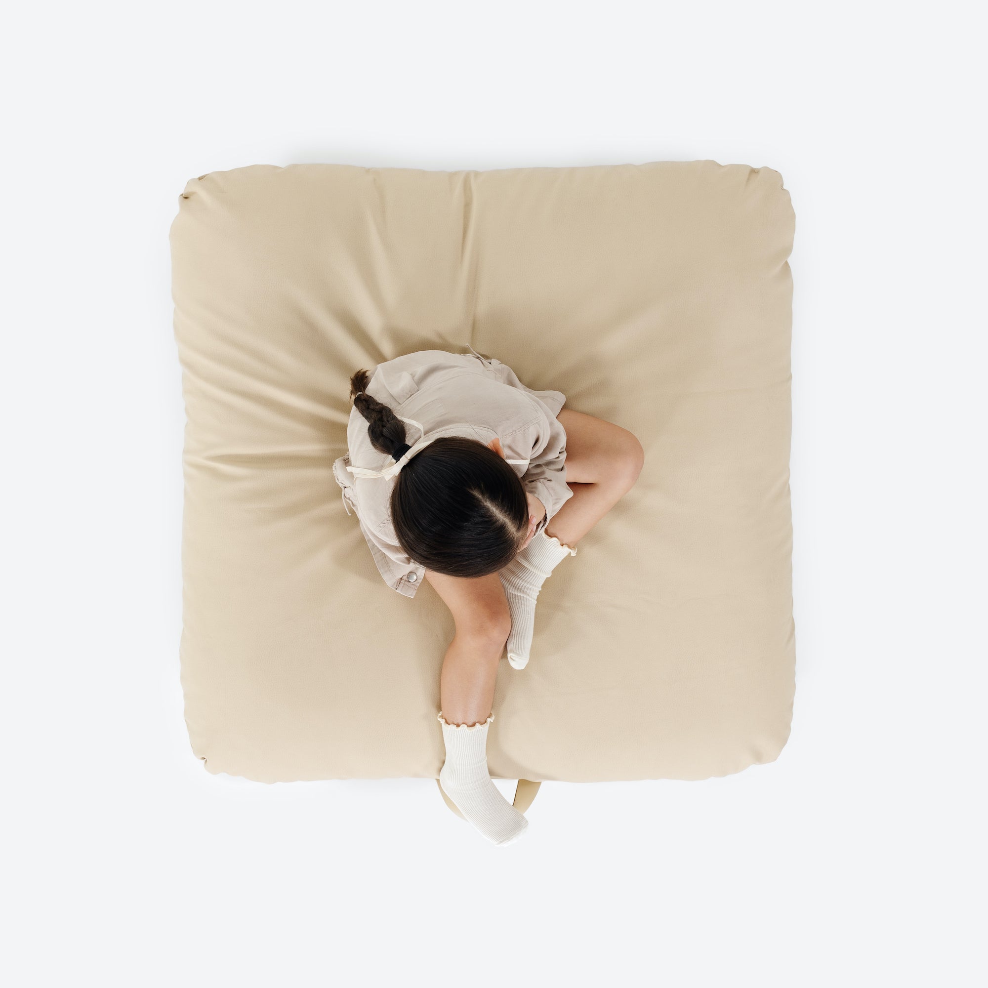 Créme / Square@overhead of girl sitting on cushion