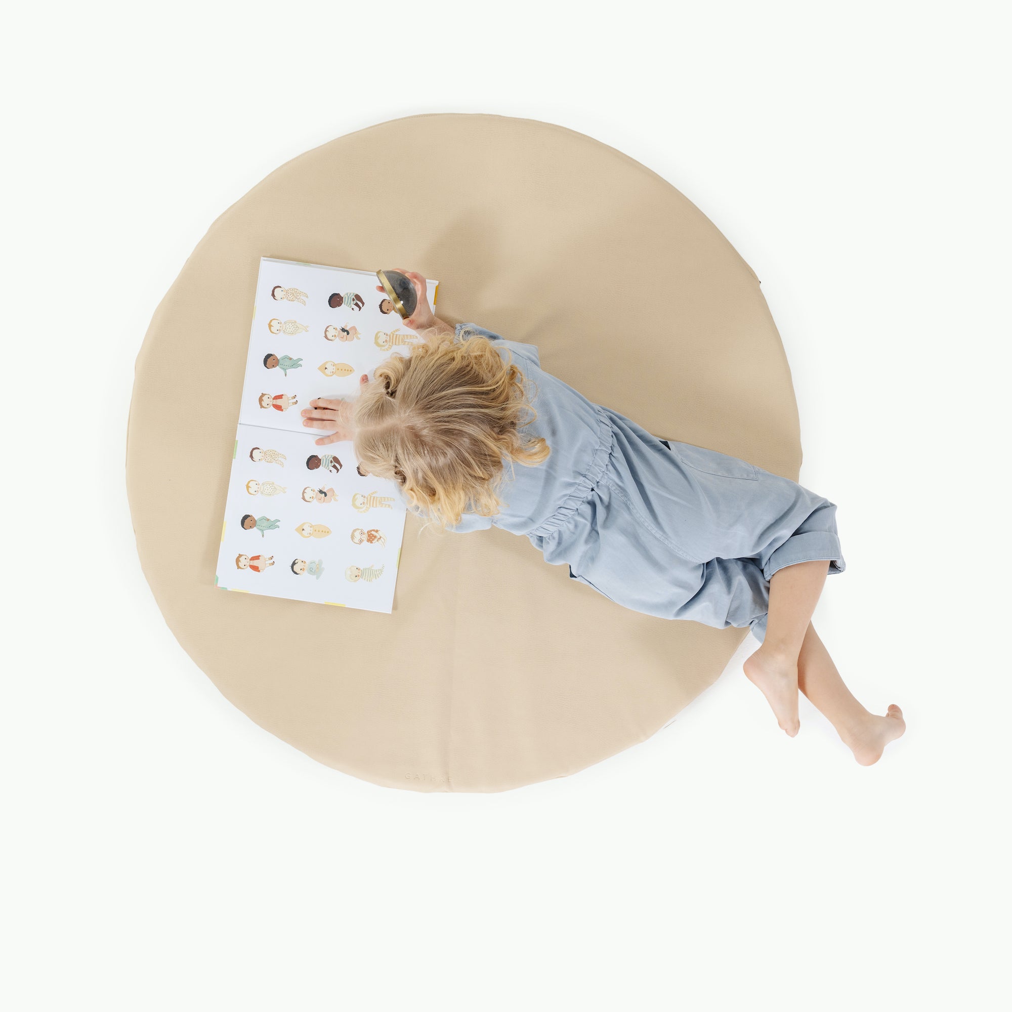 Créme / Circle@overhead of little girl playing on padded mat