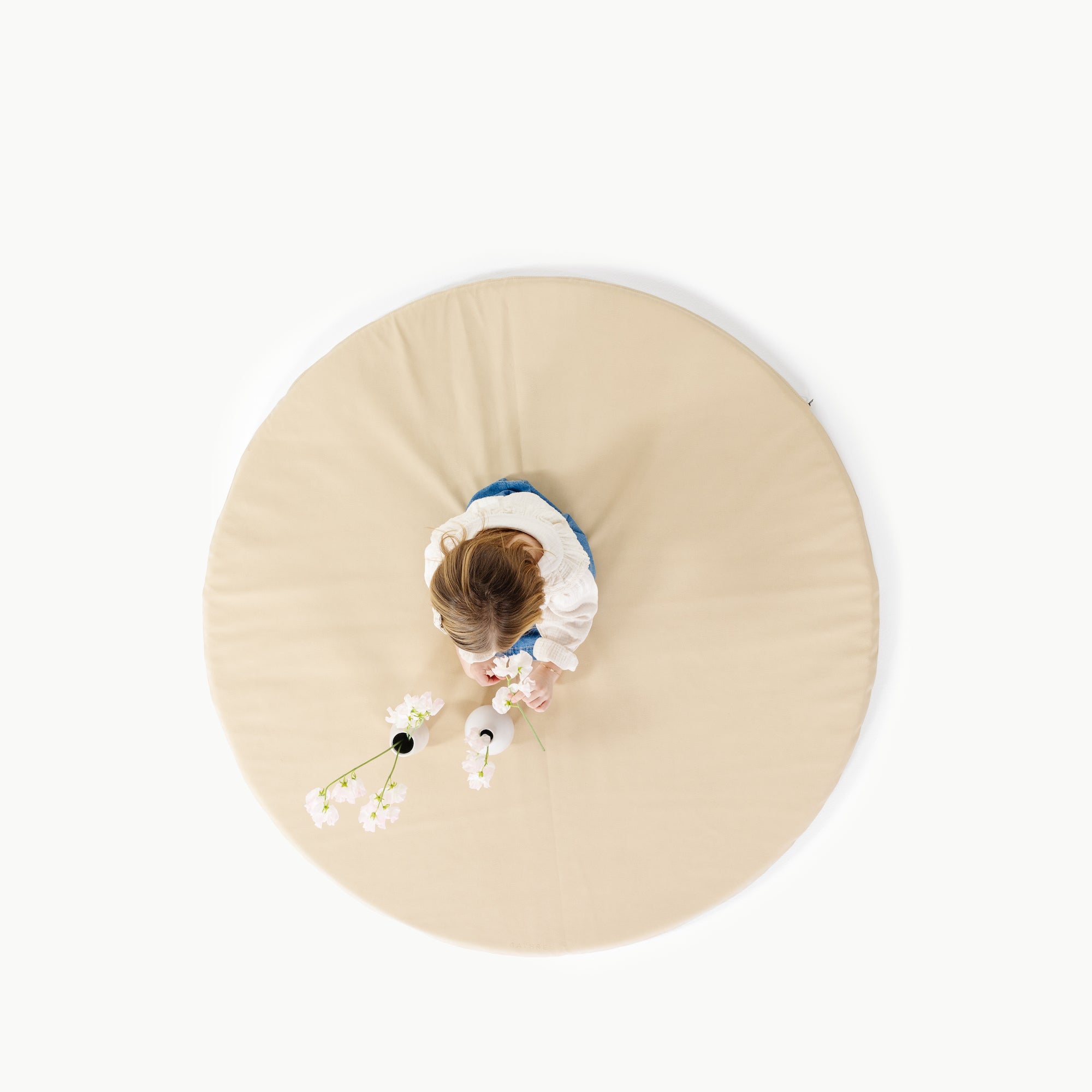 Créme@overhead of little girl playing on padded mat
