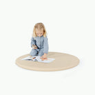 Créme / Circle@little girl playing on padded mat