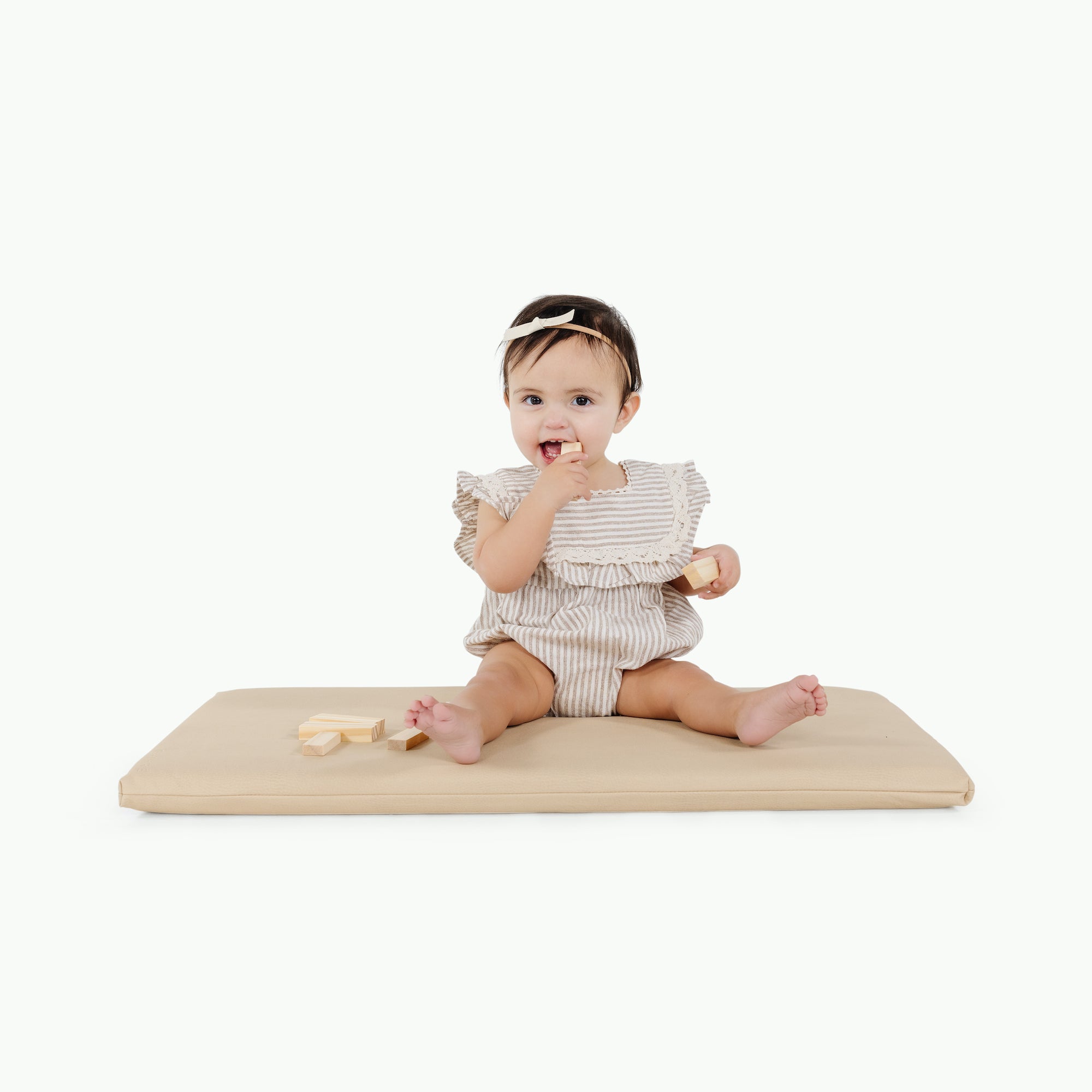 Créme@little girl sitting on padded mat