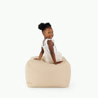 Créme / Square@little girl sitting on pouf