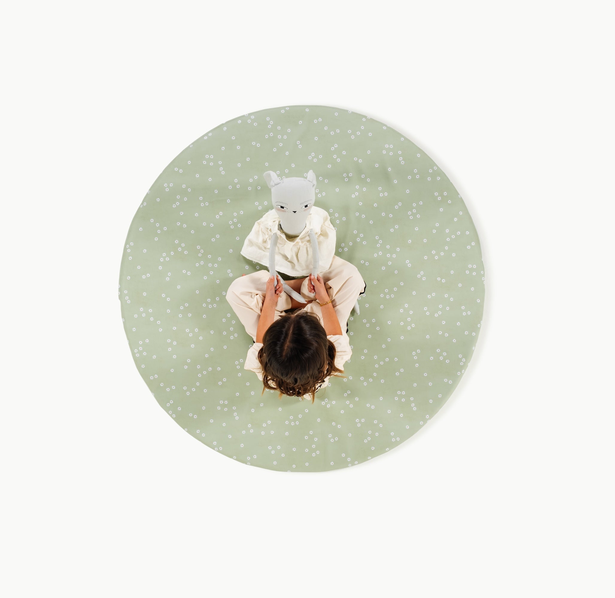 Flora@overhead of little girl sitting on padded mat